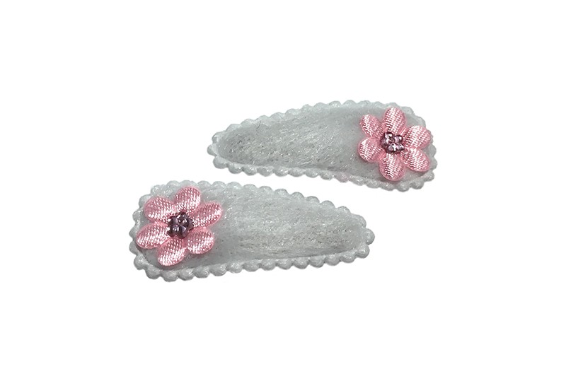 Schattig setje van 2 witte fluffie baby haarspeldjes met op elk een licht roze bloemetje. 
Afgewerkt met een klein licht roze glimmertje. 
