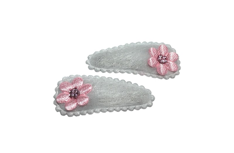 Schattig setje van 2 witte fluffie baby haarspeldjes met op elk een licht roze bloemetje. 
Afgewerkt met een klein licht roze glimmertje. 