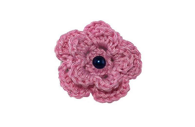 Vrolijke roze gehaakte haarbloem met een donkerblauw pareltje. Op een handige alligator haarknip van 4 centimeter.