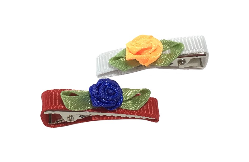 Schattig setje van 2 kleine, smalle haarknipjes. 1 knipje bekleed met rood lint en een blauw roosje. En 1 knipje bekleed met wit lint met een oranje roosje. Met op elk een cremekleurig roosje. Het knipje is een alligator knipje van ongeveer 3 centimeter. 