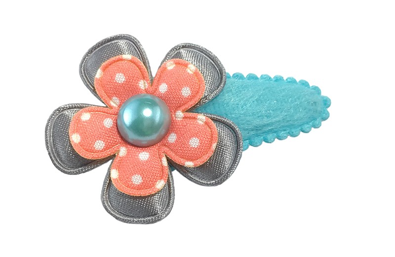 Leuk lichtblauw fluffie haarspeldje. Met daarop een effen grijze glanzende bloem en een licht oranje bloemetje met witte stippeltjes. 
Afgewerkt met een licht blauw pareltje. 