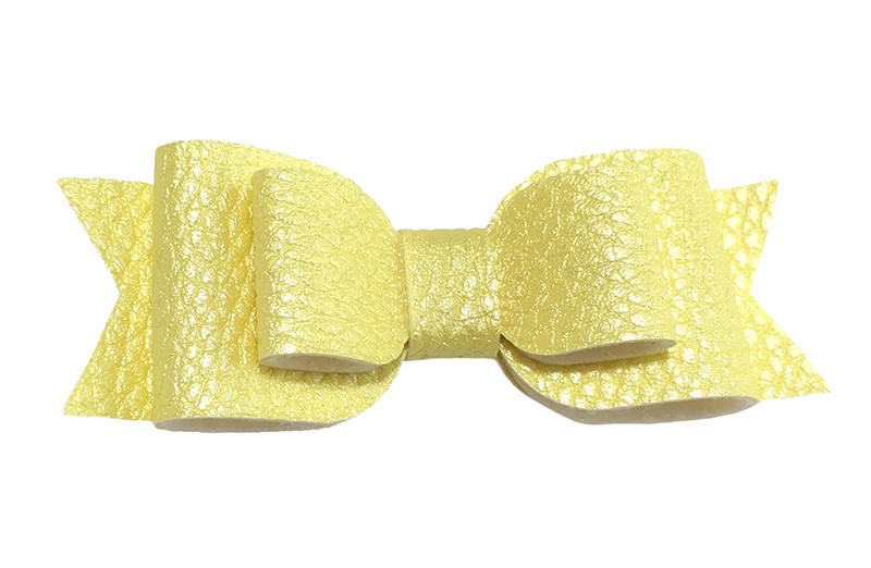 Mooi geel leren haarstrikje. 
In een mooie 3 laags look. 
Op een alligatorknipje van 4.5 centimeter bekleed met licht geel lint.