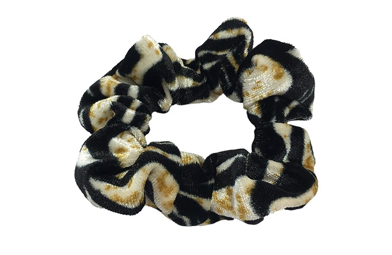 Vrolijke fluweel stoffen scrunchie met zwart bruin dieren dessin. 
Van lekker zacht materiaal. 
Heel makkelijk een leuk kapsel met deze populaire elastieken.
